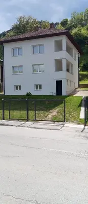 a white building with a fence in front of it at Apartmani Mušinbegović1 in Visoko