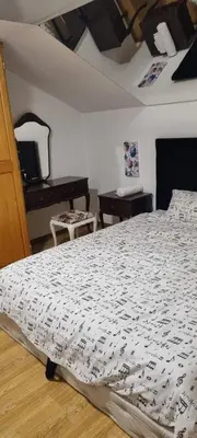 a bedroom with a bed with a black and white comforter at Barok in Tešanj