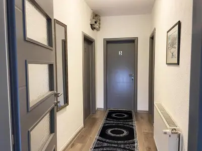 a hallway with a door and a rug on the floor at Soba za goste Kraljica 4 in Kupres