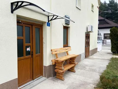 a wooden bench sitting outside of a building at Soba za goste Kraljica 3 in Kupres