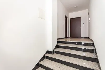 a hallway with black and white stairs and a door at Apartman Krželj B3 in Livno