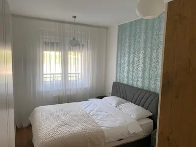 a bed in a bedroom with a window and a bedvisor at Zeus apartman in Hiseti