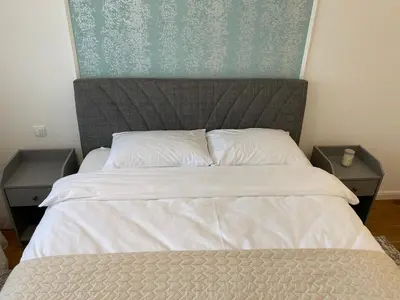 a bedroom with a large bed with two night stands at Zeus apartman in Hiseti