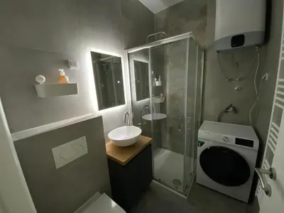 a bathroom with a sink and a shower and a toilet at Zeus apartman in Hiseti