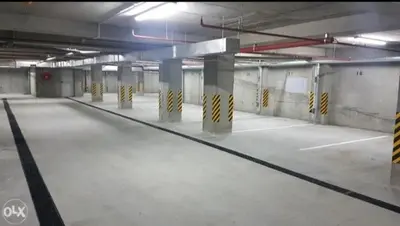 an empty parking lot with columns in a parking garage at Apartman Vrbas 1 + Podzemna garaza in Banja Luka