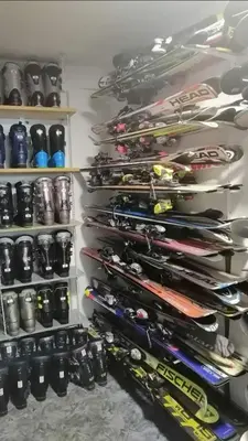 a shelf filled with lots of pairs of ski equipment at Apartman Svalina in Kupres