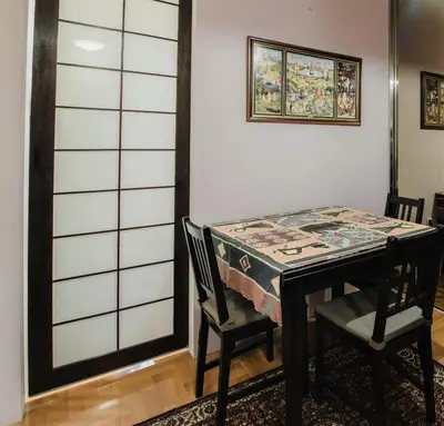 a dining room table with two chairs and a table with a table cloth at Divan Apartman u Banjaluci in Banja Luka