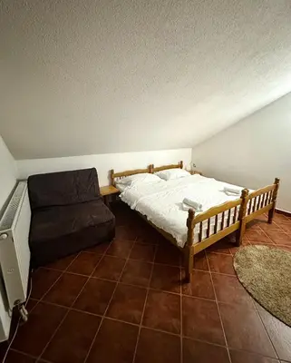 a bedroom with a bed and a couch at Apartmani Ivan in Kupres