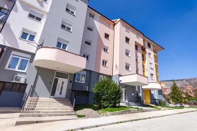 an apartment building with stairs in front of it at Apartman Krželj A3 in Livno