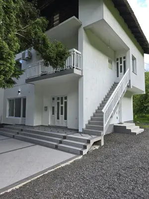 a white house with stairs in front of it at Riverstone Retreat Villa in Jajce