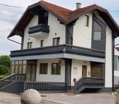 a large white house with a brown roof at Teal Apartment 2 in Bihać