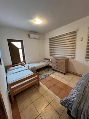 a room with two beds and a table in it at Teal Apartments in Bihać