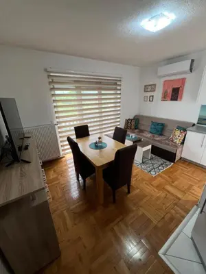 a living room with a table and chairs at Teal Apartments in Bihać