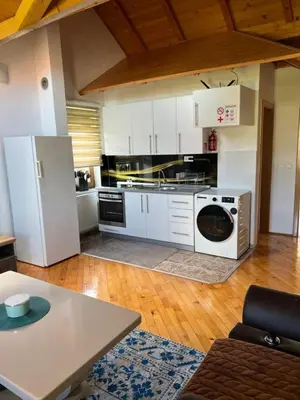 a kitchen with a white refrigerator and a washer at Teal Apartments in Bihać