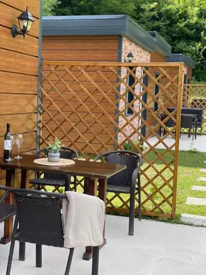 a patio with a table and chairs and a fence at Bungalovi izvor Plive 2 in Šipovo