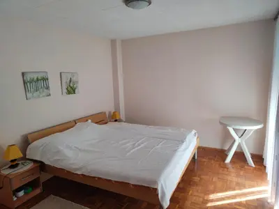 a bedroom with a bed and a table in it at Apartman Stella in Banja Luka