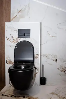 a black toilet in a bathroom with a marble wall at Apartmani VIZIJA in Visoko