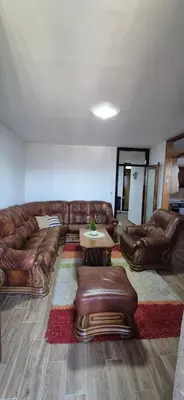 a living room with a leather couch and a table at Center Heritage Apartment in Teslić
