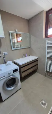 a bathroom with a washing machine and a sink at Center Heritage Apartment in Teslić