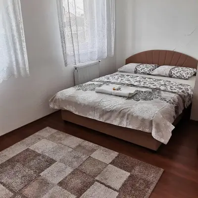 a bedroom with two beds and a rug at Stan na dan Banja Luka in Banja Luka