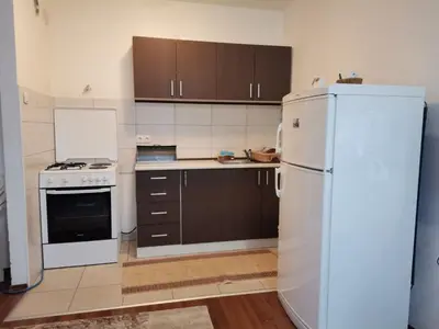 a kitchen with a white refrigerator and brown cabinets at Stan na dan Banja Luka in Banja Luka