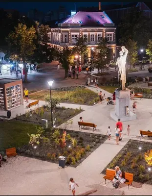 a group of people walking around a park at night at Apartmani Kastel 3 in Banja Luka