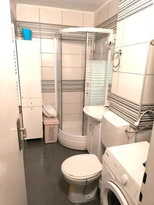 a bathroom with a toilet and a shower and a washing machine at Apartment Sneki Banja Luka in Banja Luka