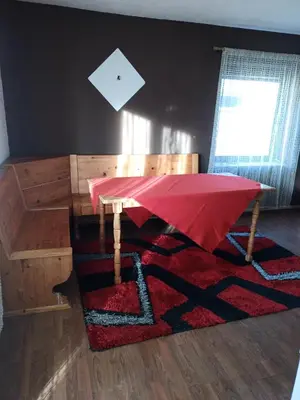 a table with a red umbrella on top of a rug at apartman SM IK 5 in Šujica