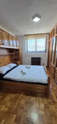 a bedroom with a large bed with blue sheets at Center Heritage Two-bedroom Apartment in Teslić