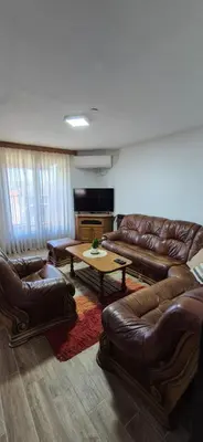 a living room with leather couches and a table at Center Heritage Two-bedroom Apartment in Teslić
