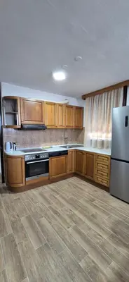 a large kitchen with wooden cabinets and a refrigerator at Center Heritage Two-bedroom Apartment in Teslić