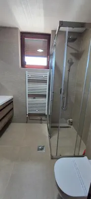 a bathroom with a shower and a toilet at Center Heritage Two-bedroom Apartment in Teslić