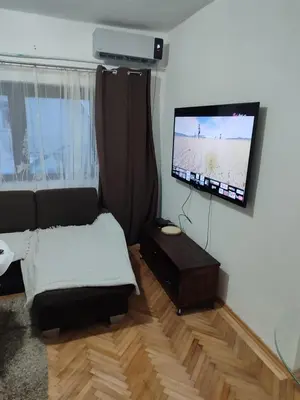 a living room with a couch and a flat screen tv at Apartman Luna in Vrbanja