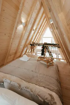 a bedroom with a bed in a wooden attic at Hygge house in Banja Luka