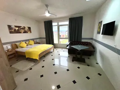 a bedroom with a yellow bed and a window at Studio Apartman Orhideja in Sanski most