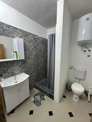 a bathroom with a shower and a toilet and a sink at Studio Apartman Orhideja in Sanski most