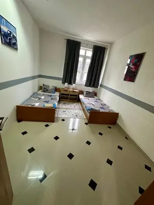 a room with two beds in a room with a floor at Apartman Orhideja za 4 osobe in Sanski most