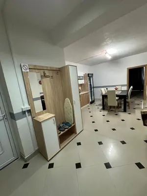 a room with a kitchen and a table with a refrigerator at Apartmani Orhideja za 4 osobe in Sanski most