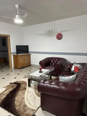 a living room with a leather couch and a coffee table at Apartmani Orhideja za 4 osobe in Sanski most