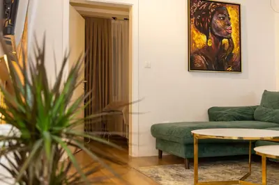 a living room with a green couch and a painting at Urban Studio II