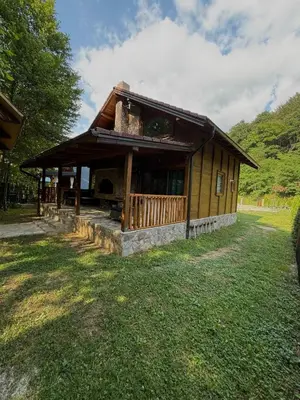 a small building with a porch on a grass field at UNA Dream in Ivišovo Greblje