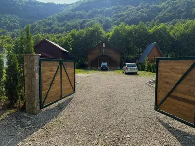 a gate to a barn with a car parked in the driveway at UNA Dream in Bihać