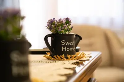 a black coffee cup with purple flowers on a table at GRADINA - Stan na dan in Doboj