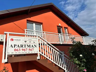 a sign on the side of a red building at Sanlej Apartman