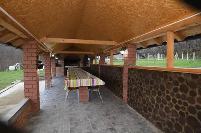 a pavilion with a table and chairs on a patio at Ivanović Vikendica