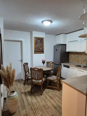a kitchen with a table and chairs and a refrigerator at Apartment D in Krndija