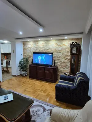 a living room with a flat screen tv on a brick wall at Apartment D in Krndija