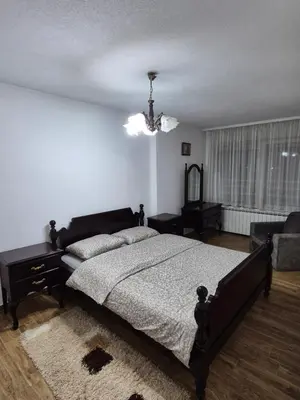 a bedroom with a large bed and a chandelier at Apartment D&D in Krndija
