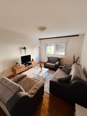 a living room with two couches and a tv at Apartman Buric