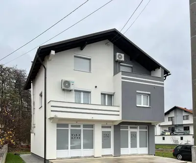 a white house with a black roof at DM Rooms l in Gornji Vakuf